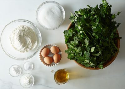 A delightful assortment of ingredients for a recipe, including fresh parsley, are neatly arranged on a table.