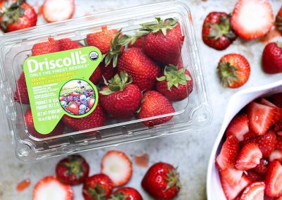Driscoll's organic strawberries in a plastic container, perfect for cooking with basil.