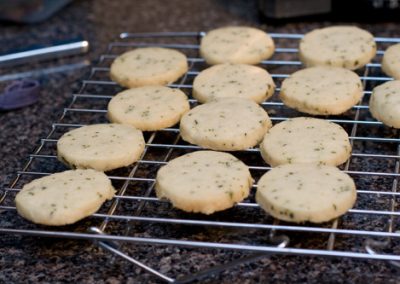 A rack of cookies on a cooling rack during baking, with sage incorporated in the recipe.
