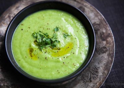 A bowl of green soup with parsley on top, perfect for cooking with parsley.